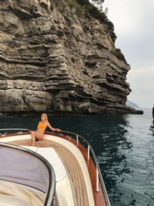 A blonde girl sunbathing on the front of the gozzo boat