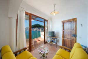 Casa Regin interior living room with yellow sofa and terrace on the sea