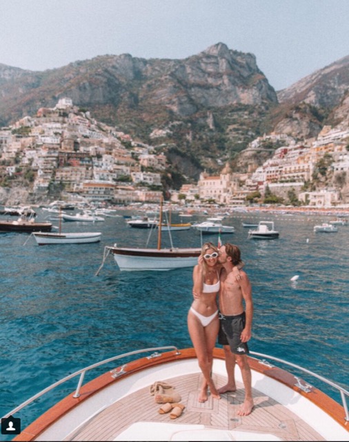 A couple kissing on the front of the boat in the sea near Positano