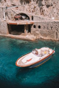 Gozzo boat view from above with crystal water of the sea and a model sunbathing