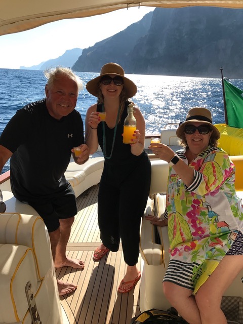 An happy family drinking limoncello on the boat