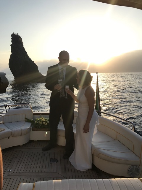 A married couple after wedding drinking prosecco on the boat